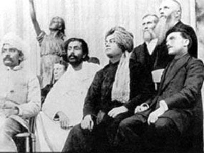 Vivekananda and Tesla (both in black) sitting next to each other.
